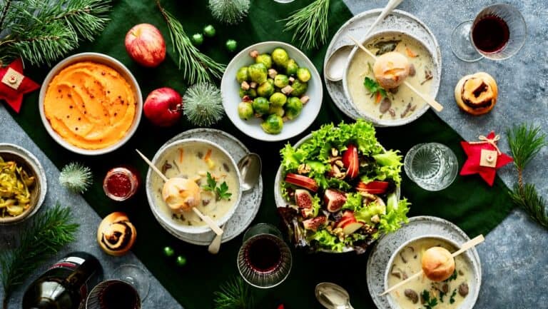 Festive Christmas party food with soups, salads, and holiday decorations.