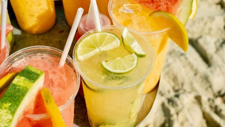 Colorful non-alcoholic fruit drinks with citrus slices and fresh fruit garnishes.