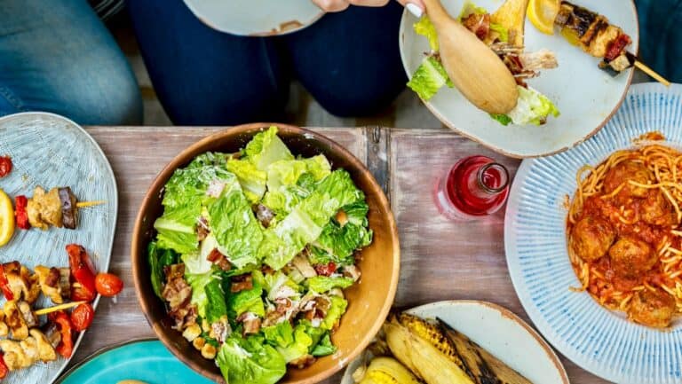 Fresh green salad and pasta dishes for a brunch spread at home.