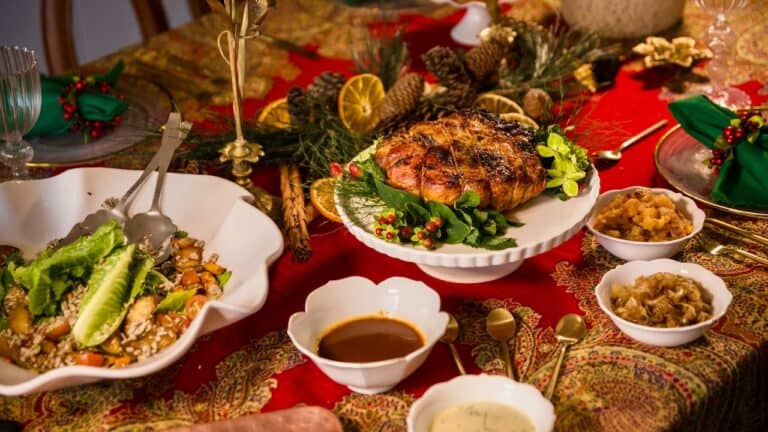 Festive Christmas table with roasted meat, salads, and side dishes for holiday celebration.