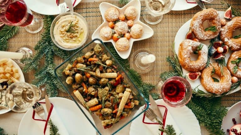 Festive Christmas party food with cookies, donuts, and a vegetable dish.