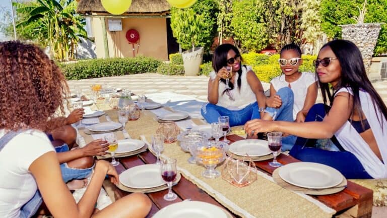 Enjoying a stylish outdoor brunch with friends in a lush garden setting.