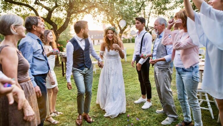 Guests celebrating a garden party with dancing and laughter outdoors.