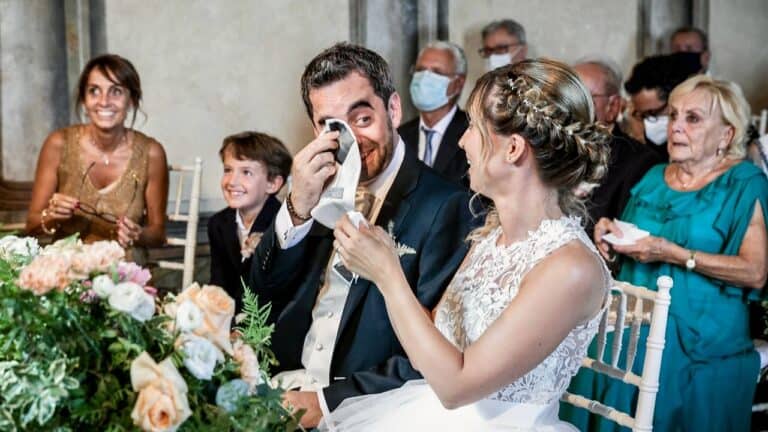 Wedding couple sharing a joyful moment with guests at their reception.