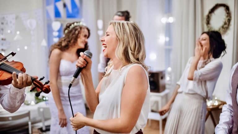 Wedding party speech with woman singing into microphone at celebration.