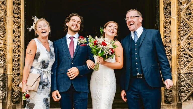 Happy wedding guests celebrating with bride and groom in elegant setting.