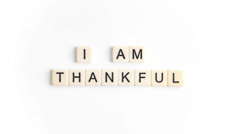 I am thankful message spelled with letter tiles on a white background.
