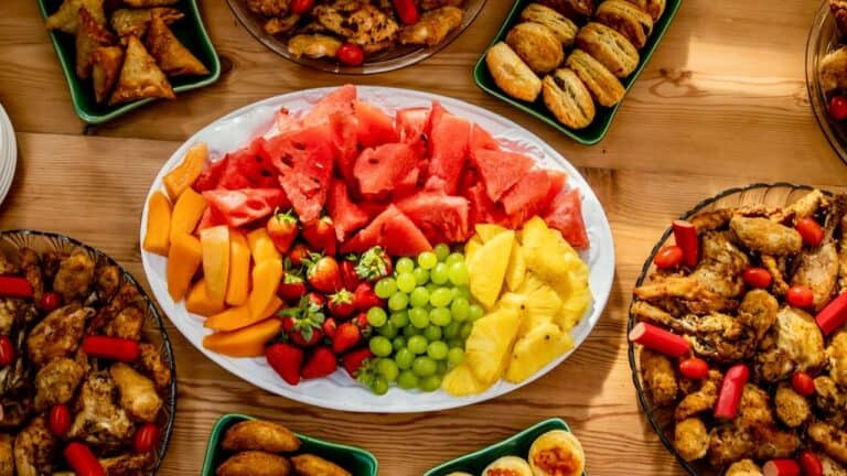 Colorful fruit platter with watermelon, grapes, pineapple, and strawberries for housewarming party.