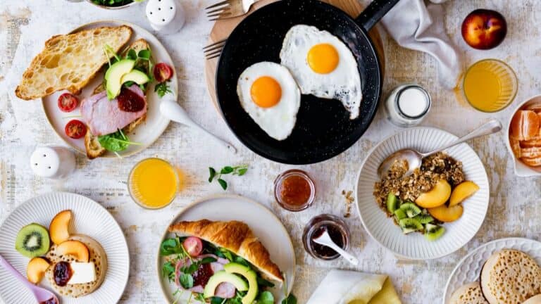 Breakfast spread with eggs, toast, croissant, and fresh fruit for a crowd.