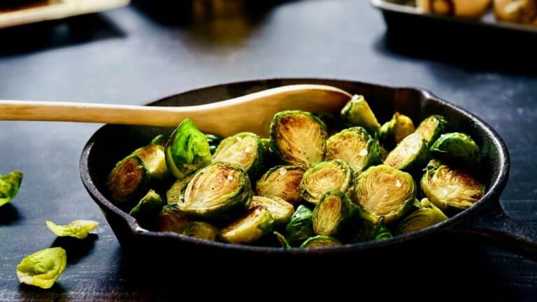 Sautéed Brussels sprouts in a black skillet, ready to serve.