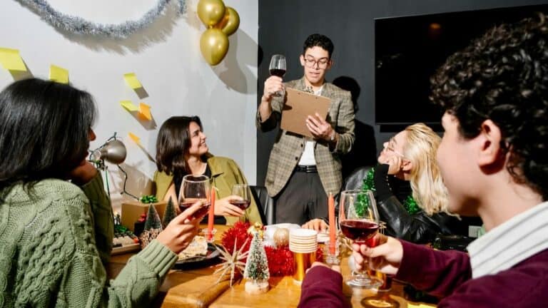 People enjoying a toast at a festive gathering with decorations and wine.