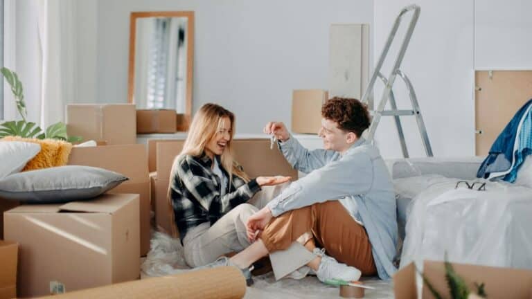 Happy couple unpacking boxes during housewarming celebration.