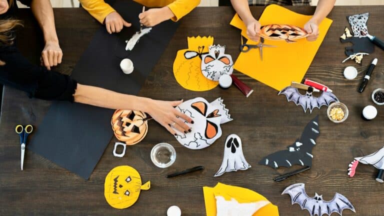 Halloween craft activity with paper decorations and craft supplies on a table.