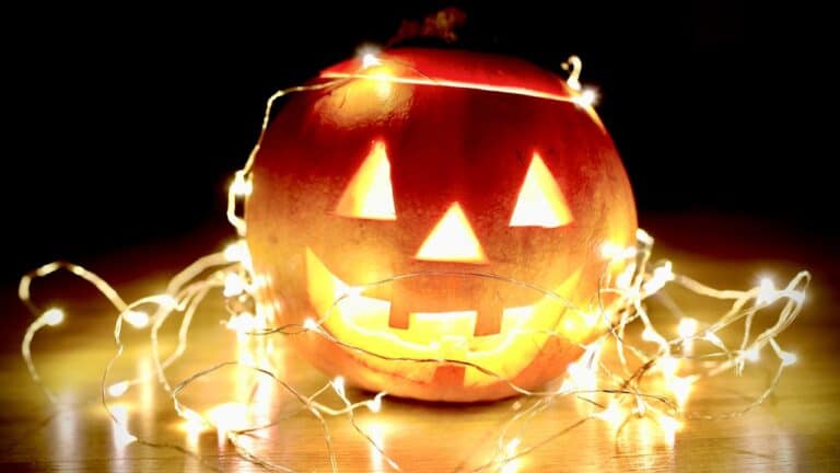 Decorative Halloween pumpkin with illuminated face and string lights.