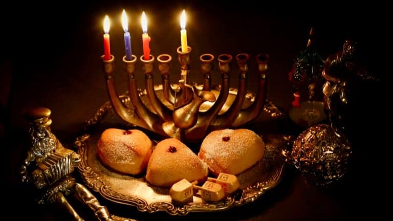 Hanukkah menorah with lit candles, traditional cookies, and decorations for Hanukkah celebration.