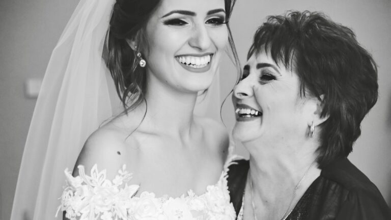 Joyful bride with her mother celebrating at wedding reception.
