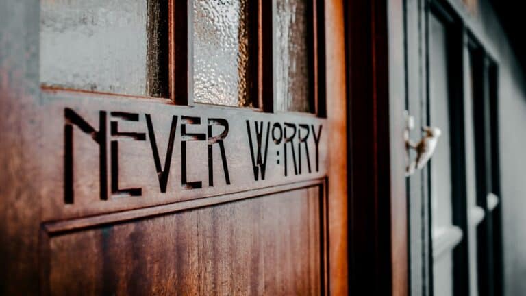 Wooden door with 'Never Worry' engraved, creating a calming atmosphere.