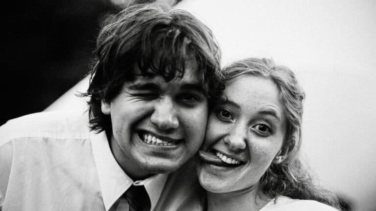 Smiling young couple in black and white, close-up portrait.