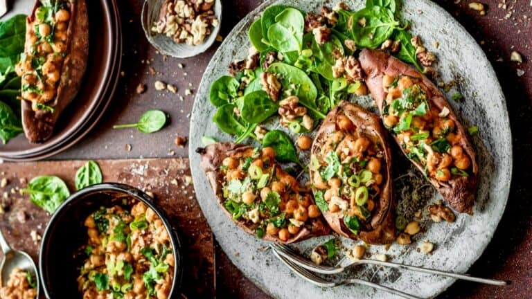 Stuffed eggplants with greens and nuts on a rustic plate for vegetarian dinner.