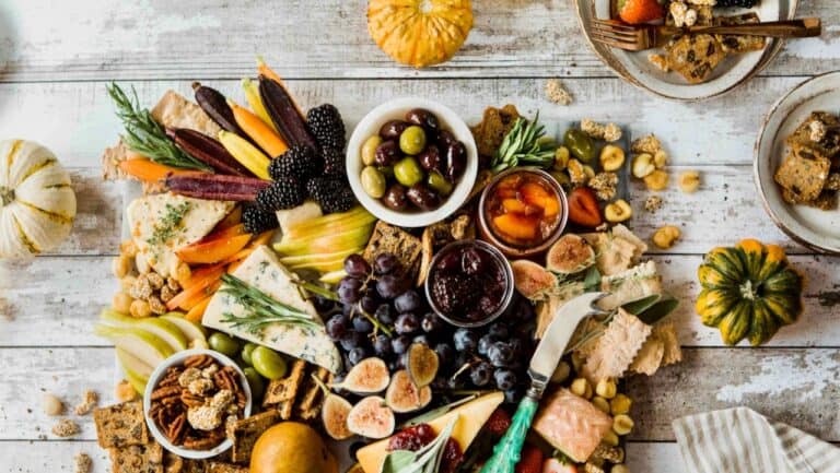 Vegetarian cheese and fruit platter for dinner party with pumpkins and nuts.